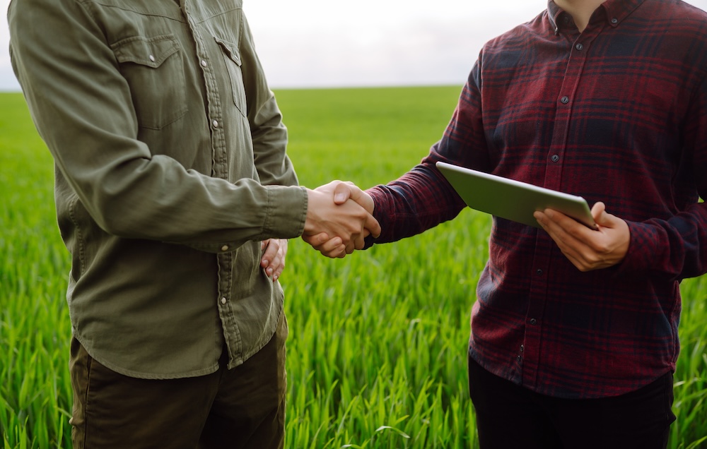 dwóch rolników podaje sobie rękę 