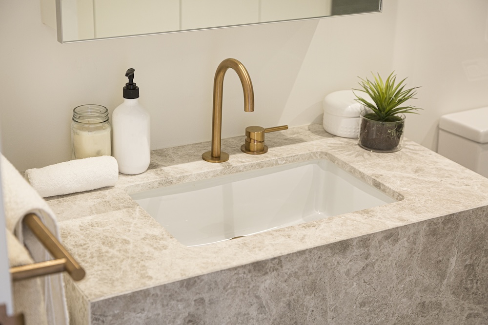 złota armatura w umywalce z kamienia 